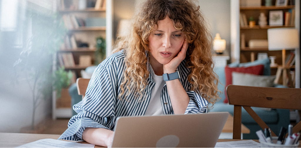 Clinician at a laptop looking fatigued